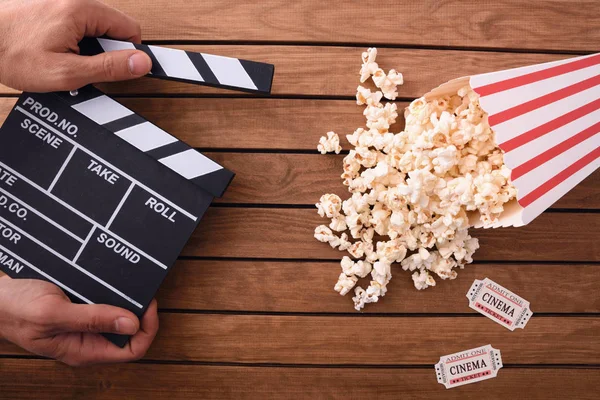 Konzept Des Kinobesuchens Mit Hand Mit Klappbrett Und Popcorn Auf — Stockfoto