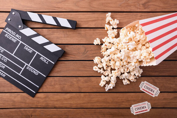 Cinema concept with related objects on wooden slat table. Concept of watching movies. Horizontal composition. Top view.