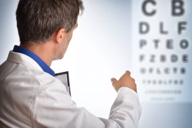 Sırtında bir tahta harf oküler gözden geçirme için gösterilen göz doktoru. Yatay kompozisyon