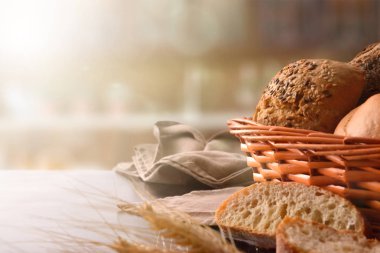 Ekmek sepeti kumaş ve siyah ahşap masa üzerinde. Önden görünüm. Yatay kompozisyon