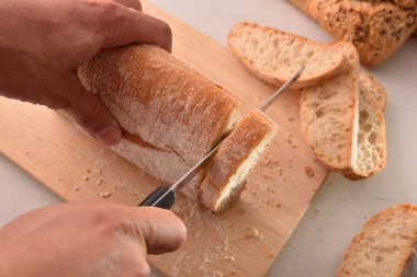 Mutfak Tezgah bir kesme tahtası dilimleri içinde Ekmek Dilimleme Şef. Üstten görünüm. Yatay kompozisyon