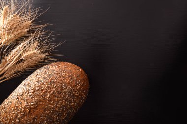 Bütün tahıl ekmeği ile hububat buğday çöp siyah bir tablo ile kapatın. Üstten görünüm. Yatay kompozisyon