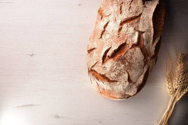 Rustik ekmek buğday çöp beyaz bir tablo ile kapatın. Üstten görünüm. Yatay kompozisyon