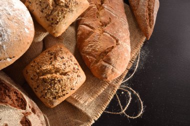 Çadır bezi mutfak siyah ahşap bir masa üzerinde ekmek türleri. Üstten görünüm. Yatay kompozisyon