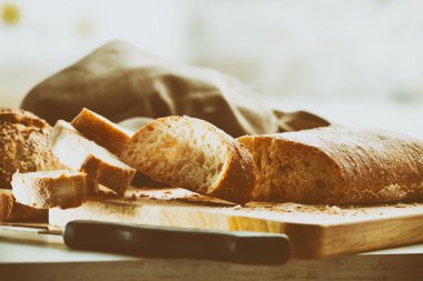 Geleneksel eski bir mutfak tezgah üzerinde kesme tahtası üzerinde ekmek dilimlenmiş. Önden görünüm. Yatay kompozisyon