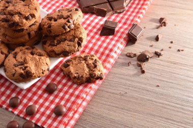 Masa örtüsü ve ahşap mutfak masasında siyah çikolata nuggets ile yuvarlak bisküvi ile kahvaltı. Yükseltilmiş görünümü. Yatay kompozisyon