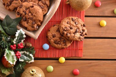Dekore edilmiş bir Noel ahşap masa üzerinde çikolata parçaları ile çerezleri kapatın. Noel'de tatlı gıda kavramı. Üstten görünüm.