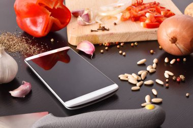 Sebze beyaz telefon siyah ahşap tablo hazırlanması. Dijital kitap tariflerde kavramı. Yatay kompozisyon. Yükseltilmiş görünümü