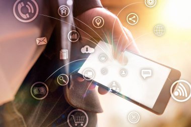 Kullanımı ve akıllı aygıtlar ile bağlantı kavramı ile bir smartphone kullanarak takım elbiseli adamla farklı işlevleri grafik simgeleri