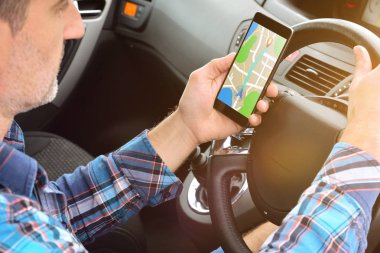 Adam bir rota bir arabada onun hedefe ulaşmak için bir uygulama ile bir cep telefonuyla danışmanlık. Yükseltilmiş arka görünüm