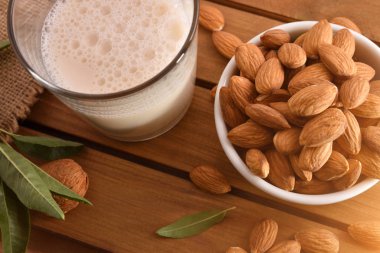 Alanında ahşap bir masa üzerinde bir cam fincan badem içki. Yatay kompozisyon. Üstten yükseltilmiş görünüm