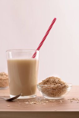 Cam ve tahıl gevreği beyaz arka plan ile mutfak bankta yulaf içki. Dikey kompozisyon. Önden görünüm