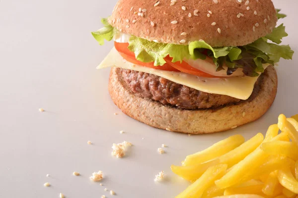 Beef burger with chips on white table. Elevated view. Horizontal composition.