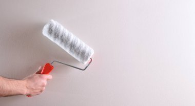 El silindir üzerinde beyaz duvar ile. Ressam ve boya malzemeleri kavramı. Yatay kompozisyon.