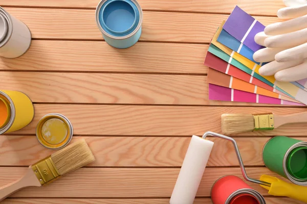 Colorful paint pots open and tools on wood table for renovation of wood and do home work. Home diy concept. Top view. Horizontal composition.