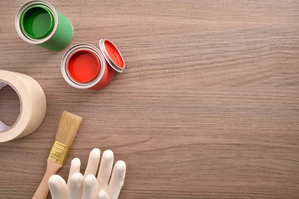 Zwei Dosen Farbe Pinsel Handschuhe Und Klebeband Auf Einem Holztisch — Stockfoto