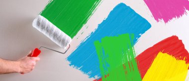 Silindir üzerinde beyaz bir duvar ile çok renkli örnekleri boyama elini. Yatay kompozisyon.