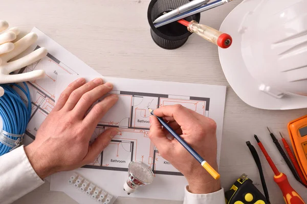 技术工程师在电力写作在一个电气图的住房安装在办公桌上与工具周围 水平合成 顶视图 — 图库照片