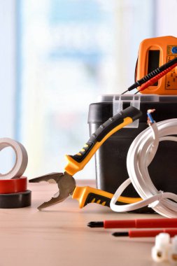 Pencere arka plan ile ahşap masa üzerinde elektrik malzeme Sergisi. Dikey kompozisyon. Önden Görünüm.