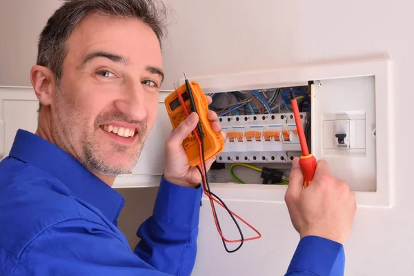 Lachende Elektricien Met Tester Schroevendraaier Reparaties Elektrische Behuizing Vak — Stockfoto