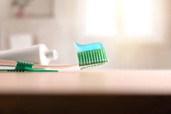 Koncepcji higieny jamy ustnej z szczoteczkę do zębów na stół z drewna w łazience — Zdjęcie stockowe