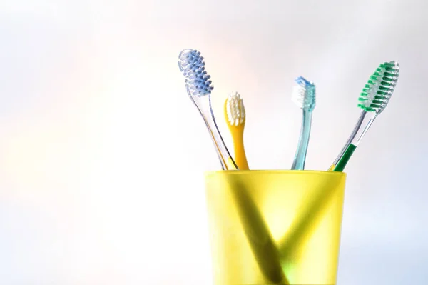 Limpeza dental familiar diária com copo de plástico amarelo com dente — Fotografia de Stock