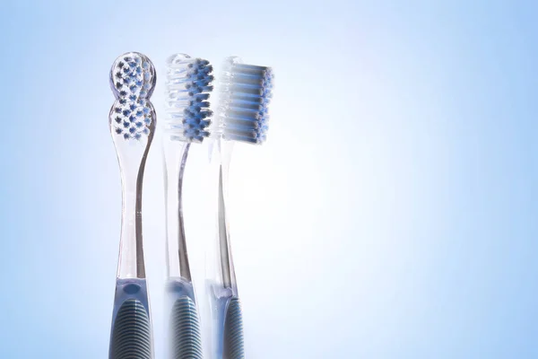 Three views of transparent blue toothbrush isolated blue — Stock Photo, Image