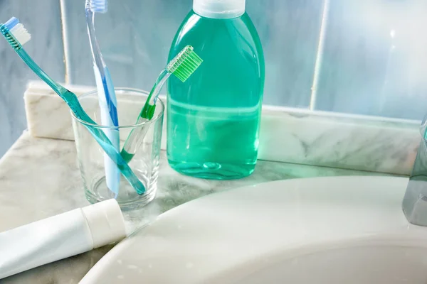 Toothbrushes toothpaste and mouthwash on a sink general view ele — Stock Photo, Image