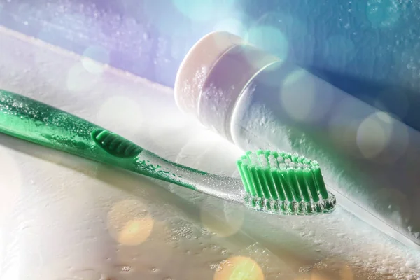 Toothbrush on a washbasin and water spray with lights elevated — Stock Photo, Image