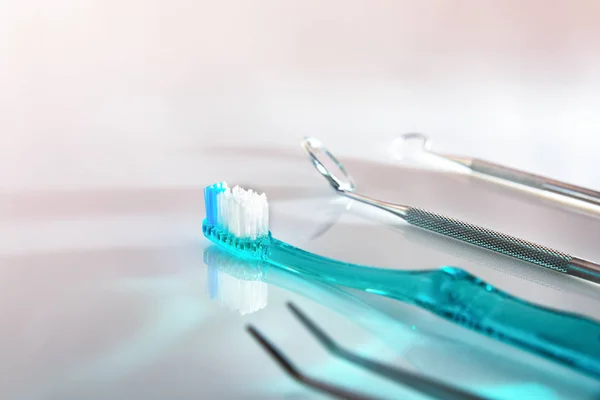 Witte tandarts tafel met blauwe tandenborstel en gereedschap — Stockfoto