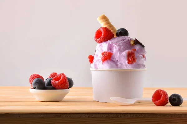 Xícara de sorvete de bagas decorada com mirtilos e framboesas — Fotografia de Stock