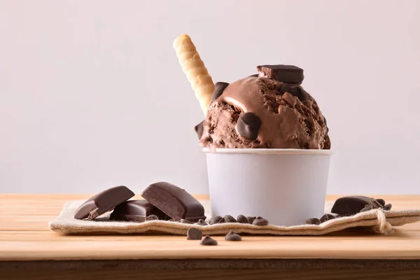 Чашка шоколадного мороженого, украшенная чипсами и вафлями — стоковое фото