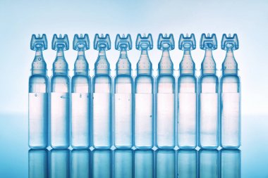 Yapay gözyaşı göz damlaları plastik pipetler mavi arka plan f