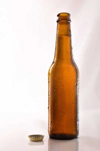 Beer bottle filled and open on glass table black background. — Stock Photo, Image