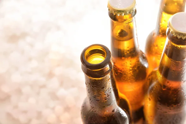 Four bottles of beer with one open on crushed ice — Stock Photo, Image