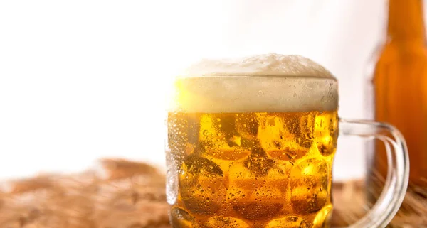 Jarro cheio de cerveja com cevada orelhas detalhe fundo branco . — Fotografia de Stock