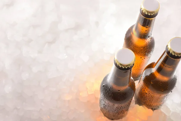 Três garrafas de cervejas fechadas em gelo picado — Fotografia de Stock