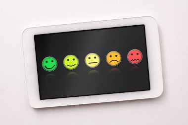 Beyaz masada tablet üzerinde memnuniyet temsili seviyeleri