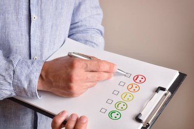 Bir çarşafa çizilmiş kızgın yüz ifadesini işaretleyen adam