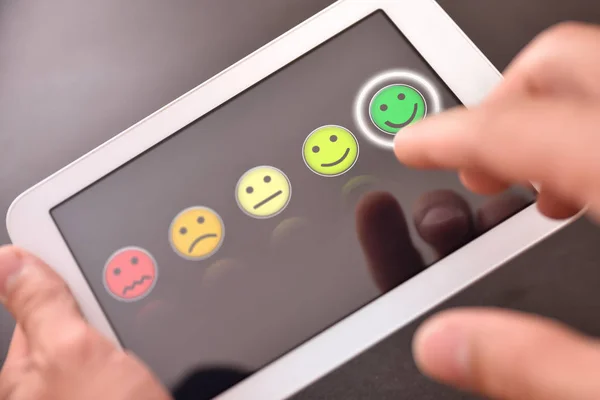 Valorizzare un servizio su un dispositivo con emoticon sullo schermo nero — Foto Stock