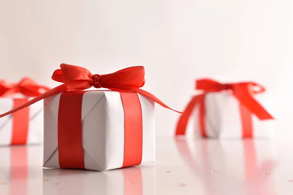 Caixa de presente de Natal branco na mesa branca com tampo de luzes — Fotografia de Stock