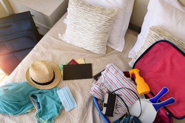 Yaz tatili aksesuarları yatak odasında Coronavirus mevsiminde tatil seyahati için hazırlanıyor. Üst görünüm
