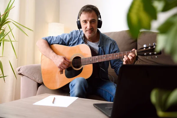 Home recording equipment for music with acoustic guitar, microphone and laptop on wooden table. Top view