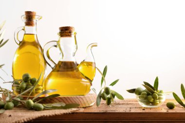 Zeytin yağı makineleri ahşap masada çiğ zeytin ve yalıtılmış beyaz arkaplanlı yapraklarla. Ön görünüm.