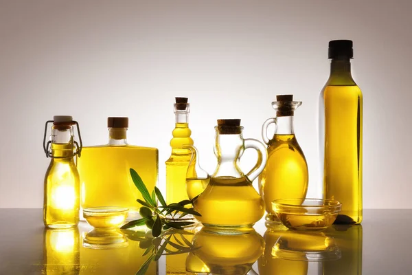 Glasbehälter Gefüllt Mit Olivenöl Hinterleuchtet Auf Glastisch Und Grauem Farbverlauf — Stockfoto