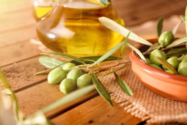 Zeytin yağı dolu bir konteynır ile ahşap bir masanın üzerindeki ağaçtan yağlar. Yüksek görünüm.
