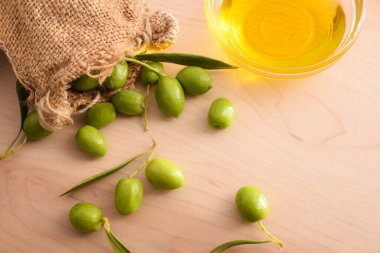 Cam kabın içinde zeytinyağı tohumu hazırlamak vücut ve mutfak bakımı için masa ve zeytin çuvalına. Üst görünüm.
