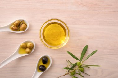 Mutfak tezgahındaki cam kaselerde zeytinli kaşık ve sebze yağı. Üst görünüm.