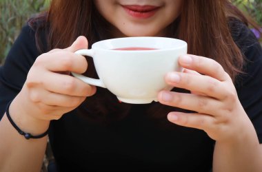 Birisi çay veya sıcak çay ya da sıcak gül çay içiyor