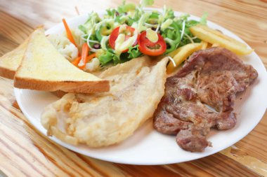 domuz eti biftek ve Balık biftek salatası ve patates kızartması ile